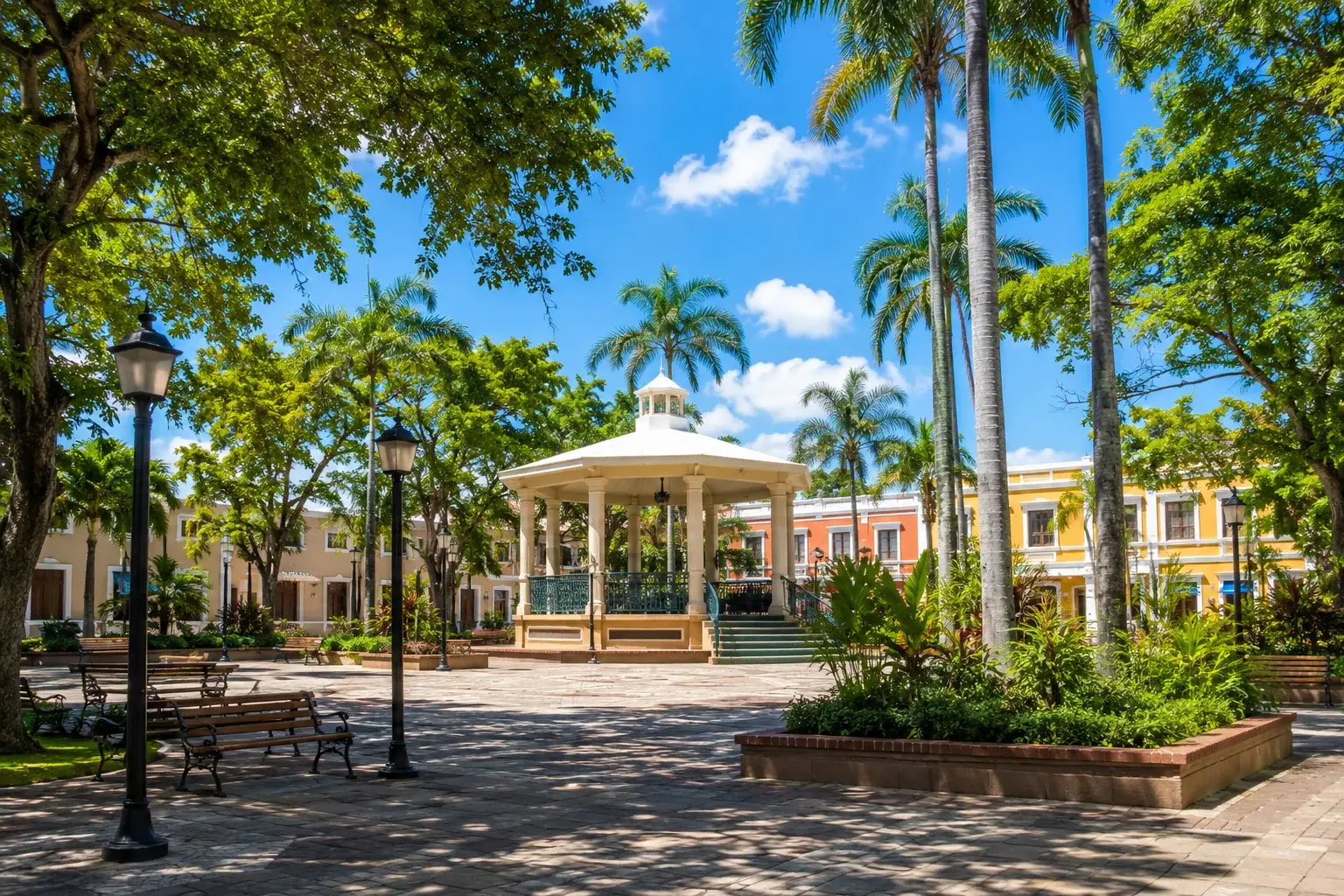 Dorado Town Plaza in Dorado, Puerto Rico, featuring a traditional gazebo, palm trees, tropical gardens, colonial-inspired architecture, and a peaceful public square.