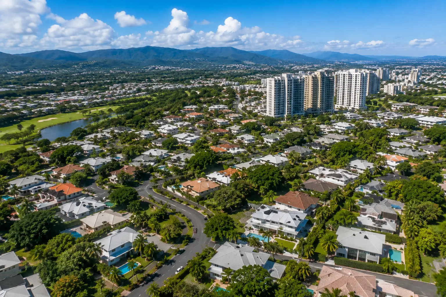 Aerial view of Torrimar in Guaynabo, Puerto Rico, featuring upscale homes, tree-lined streets, tropical landscaping, and nearby modern residential towers.