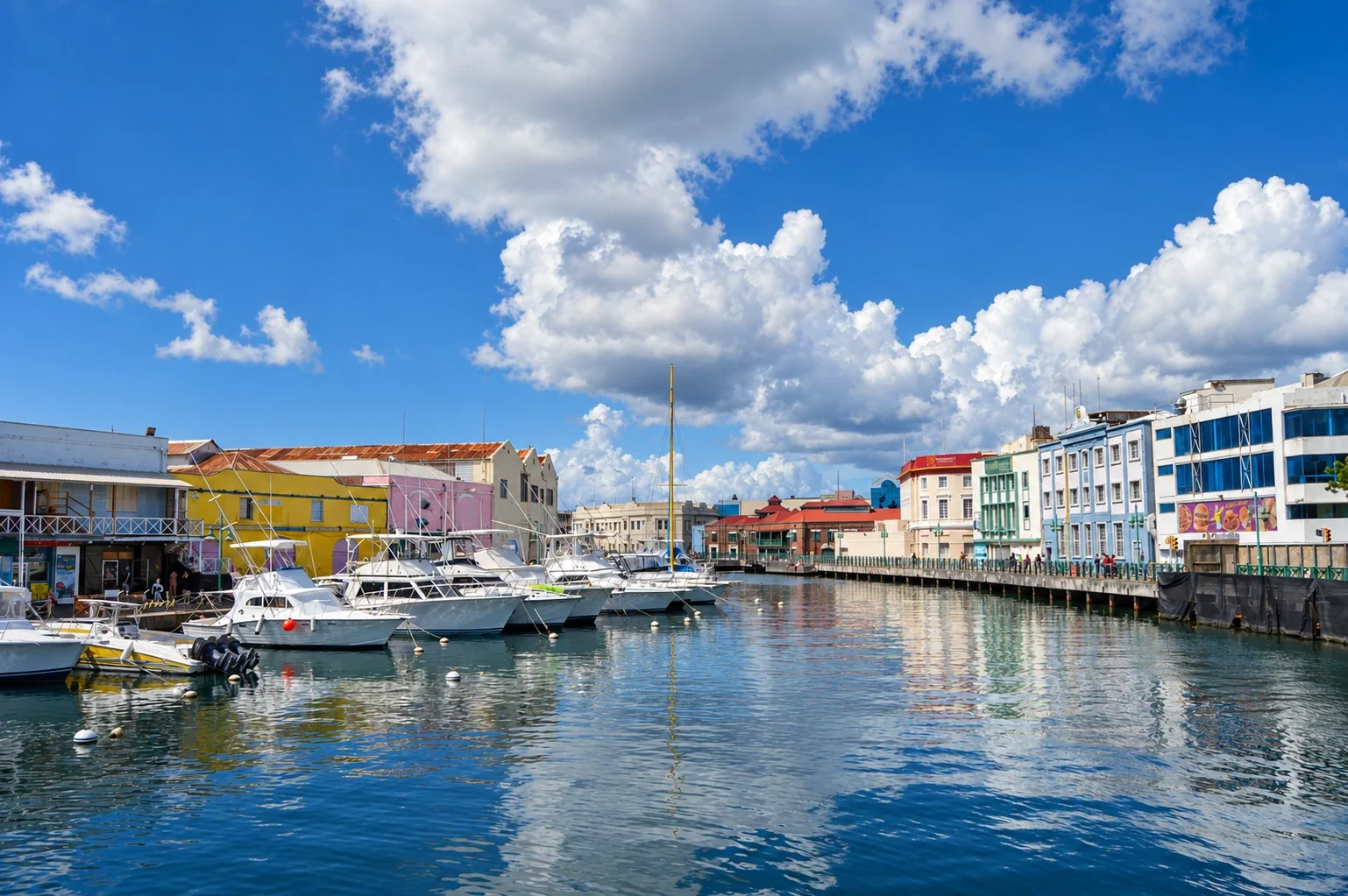 Boats moored beside waterfront buildings along the Careenage in Bridgetown, Barbados