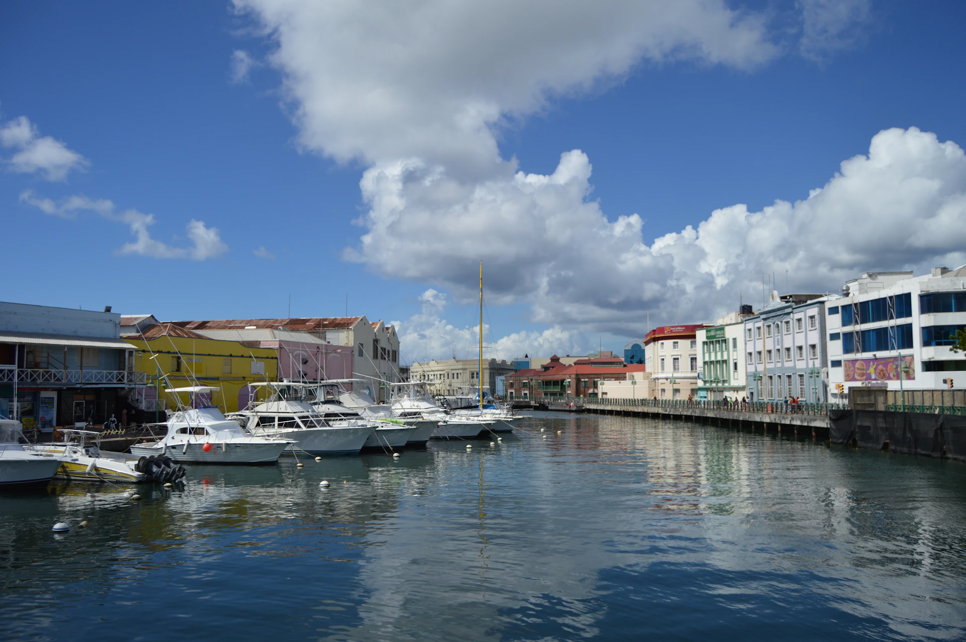 Boats moored beside waterfront buildings along the Careenage in Bridgetown, Barbados