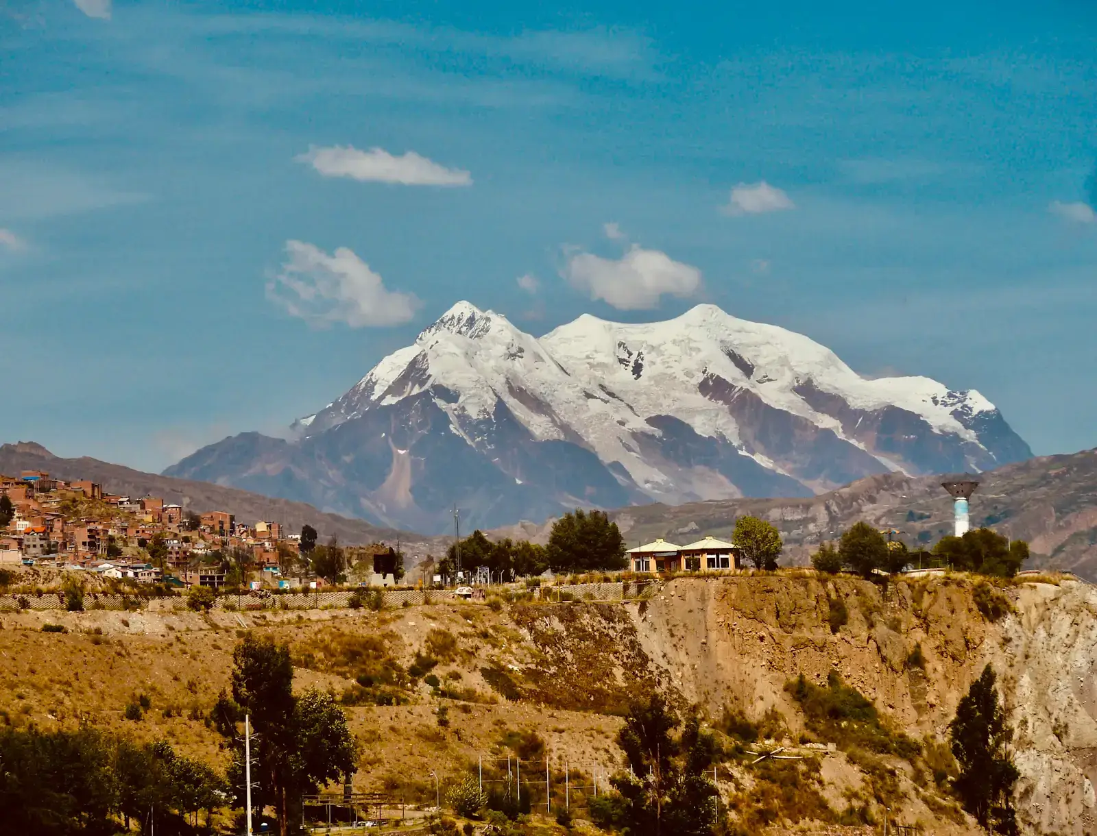 Buildings and hillside terrain in La Paz, Bolivia, below snow-covered Illimani mountain