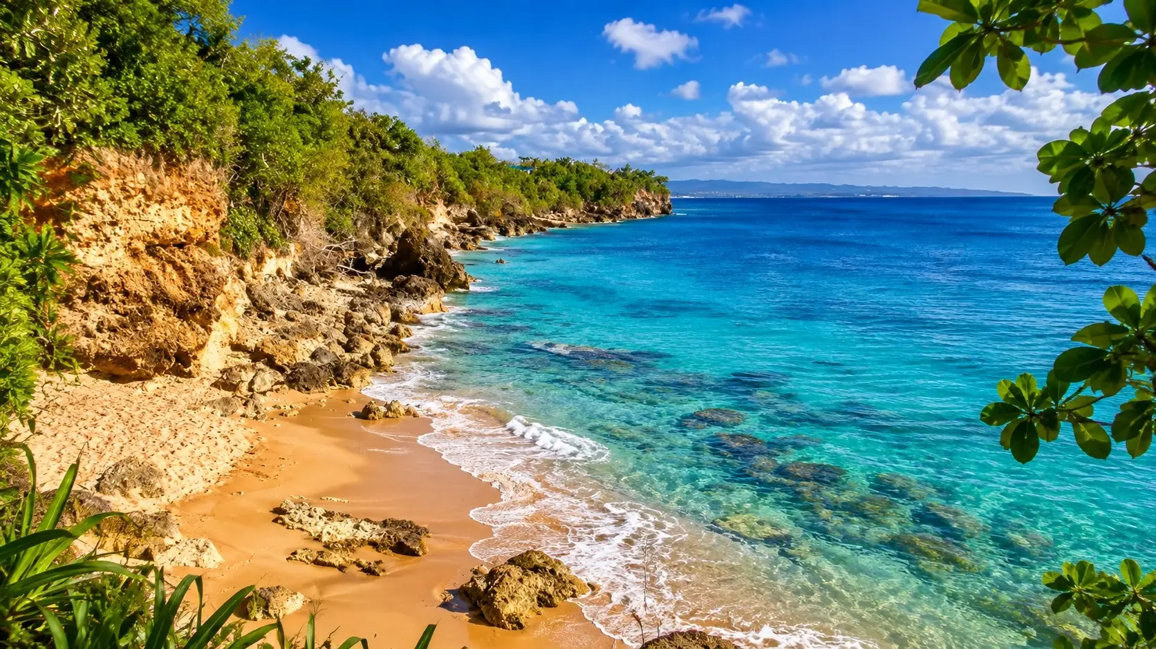 Peña Blanca in Aguadilla, Puerto Rico, with a secluded sandy beach, rocky coastline, lush tropical vegetation, and clear turquoise Caribbean water.