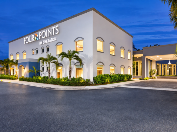 Four Points Caguas Real hotel exterior with palms and an entrance driveway.
