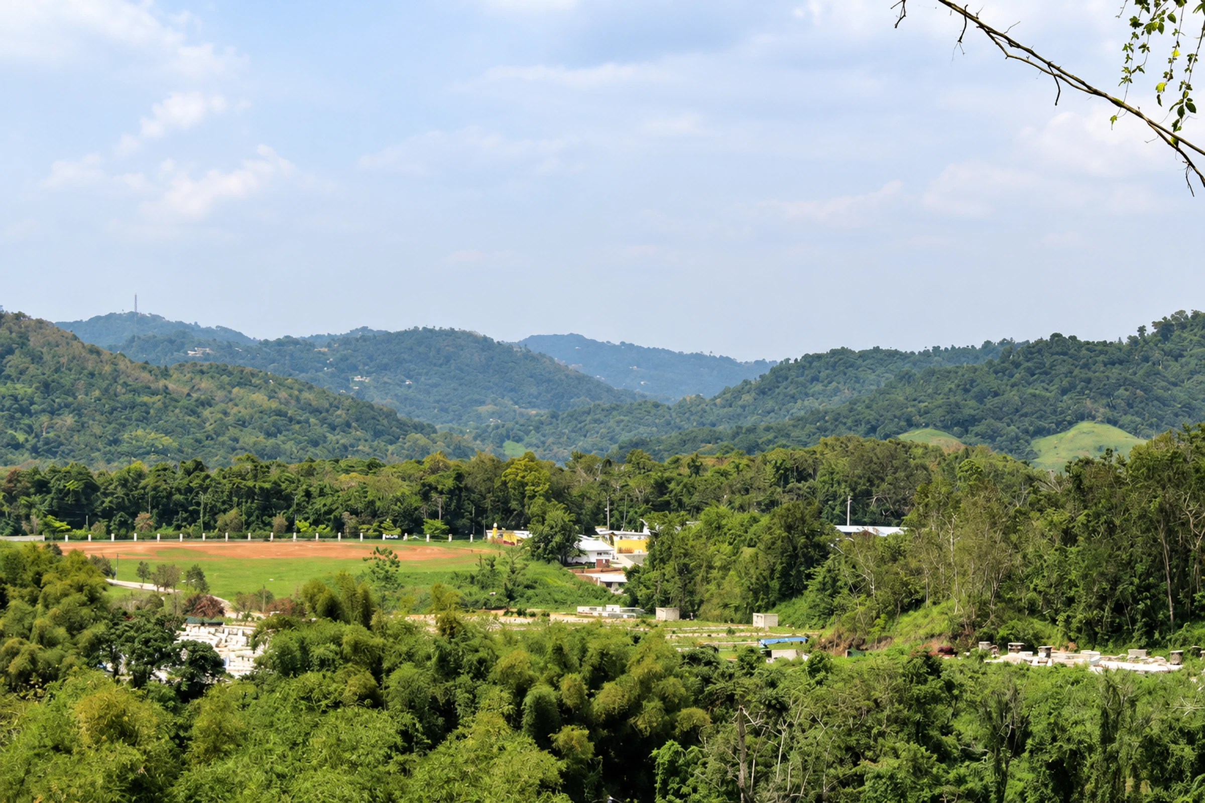 Green fields, scattered buildings and mountain ridges in Río Cañas, Caguas.