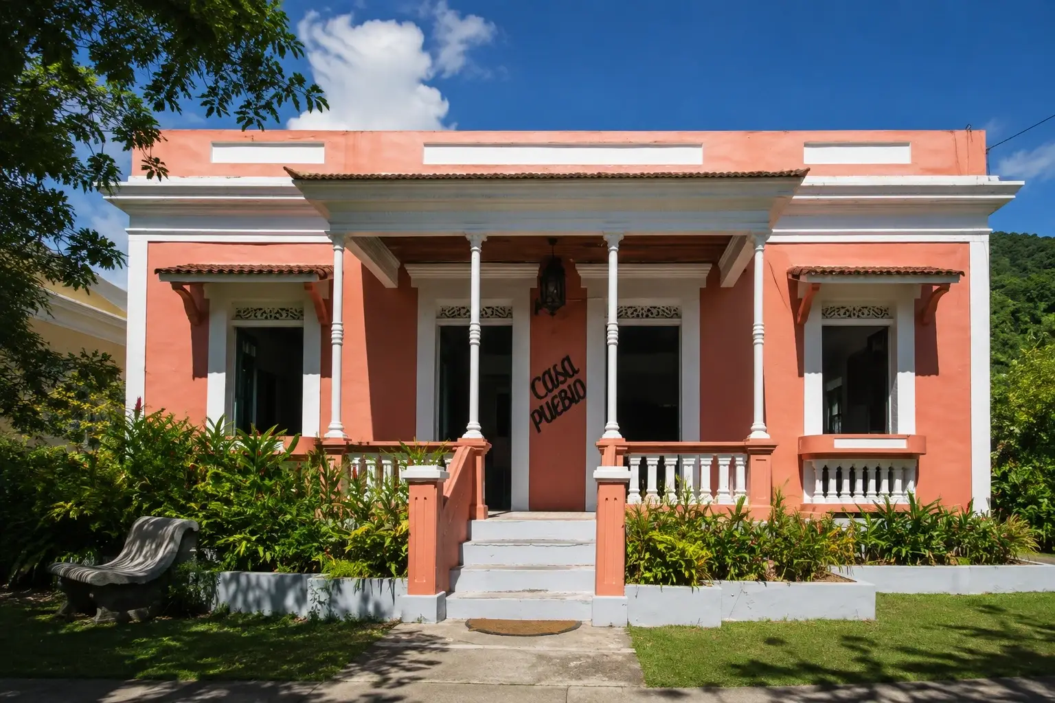 Historic coral-colored Casa Pueblo building surrounded by tropical vegetation in Adjuntas, Puerto Rico.