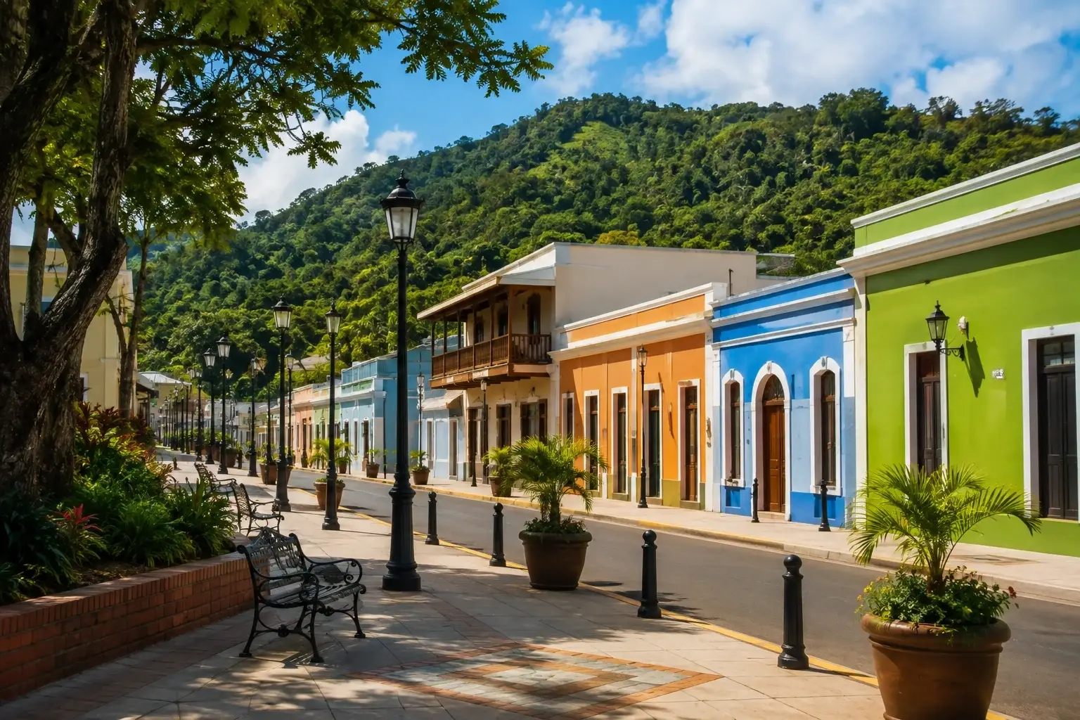 Colorful traditional buildings and a mountain backdrop in downtown Adjuntas, Puerto Rico.