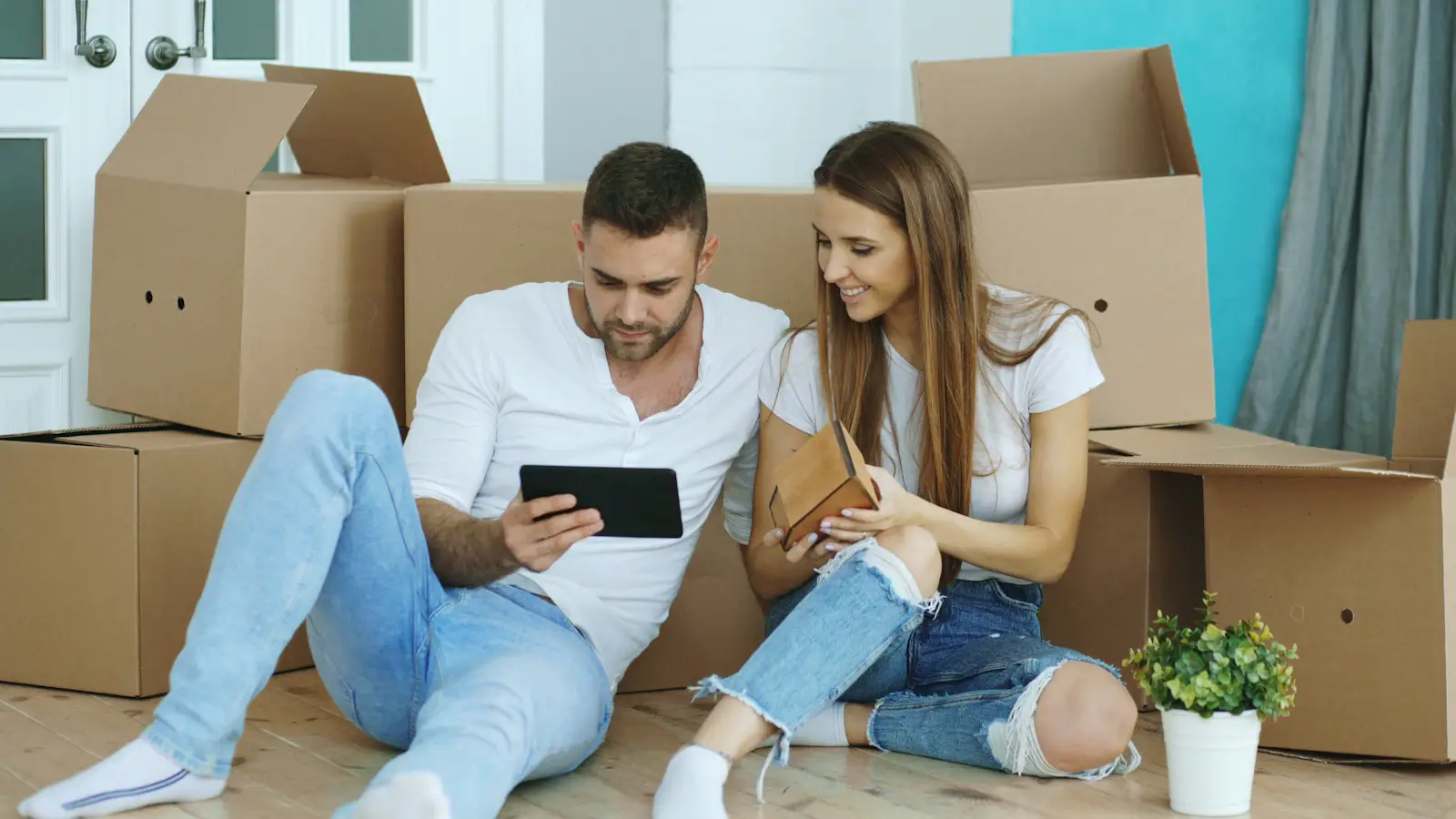 Couple planning their move while unpacking boxes in a new home