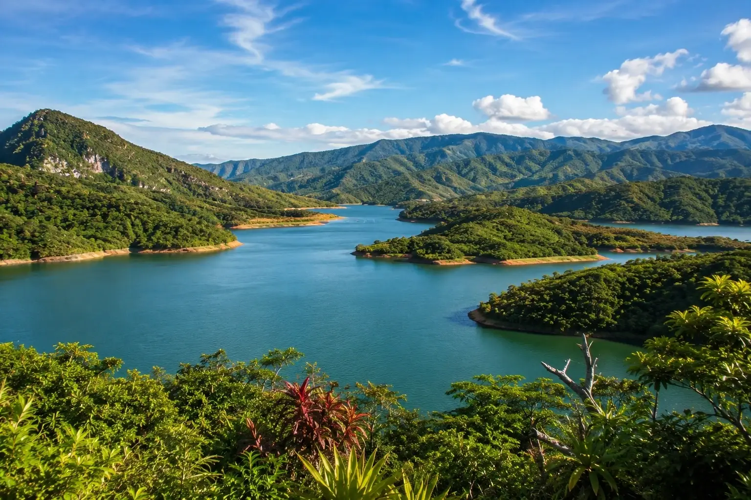Panoramic view of Lago Garzas surrounded by lush green mountains in Adjuntas, Puerto Rico.