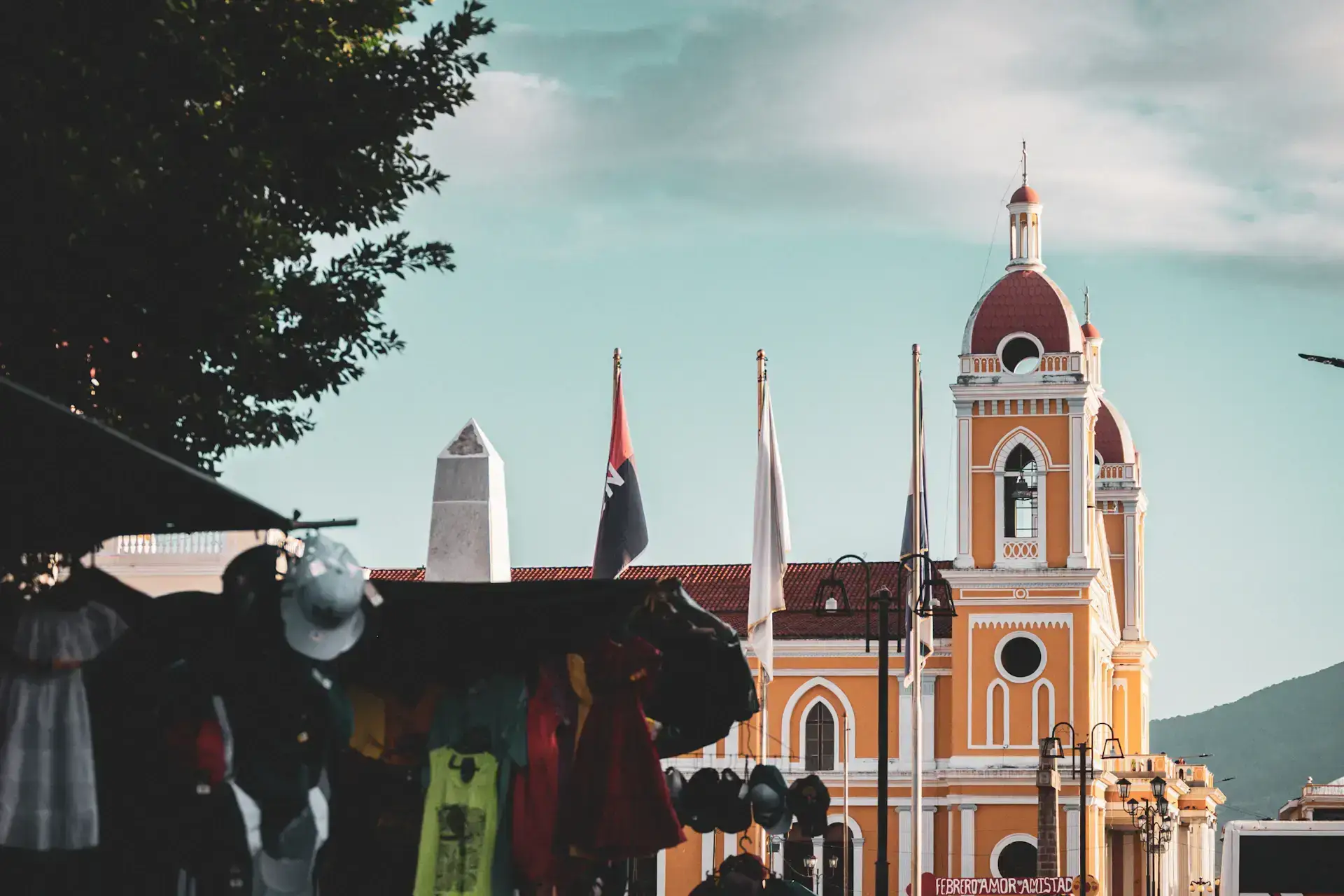 Orange cathedral tower and market stalls in Granada, Nicaragua
