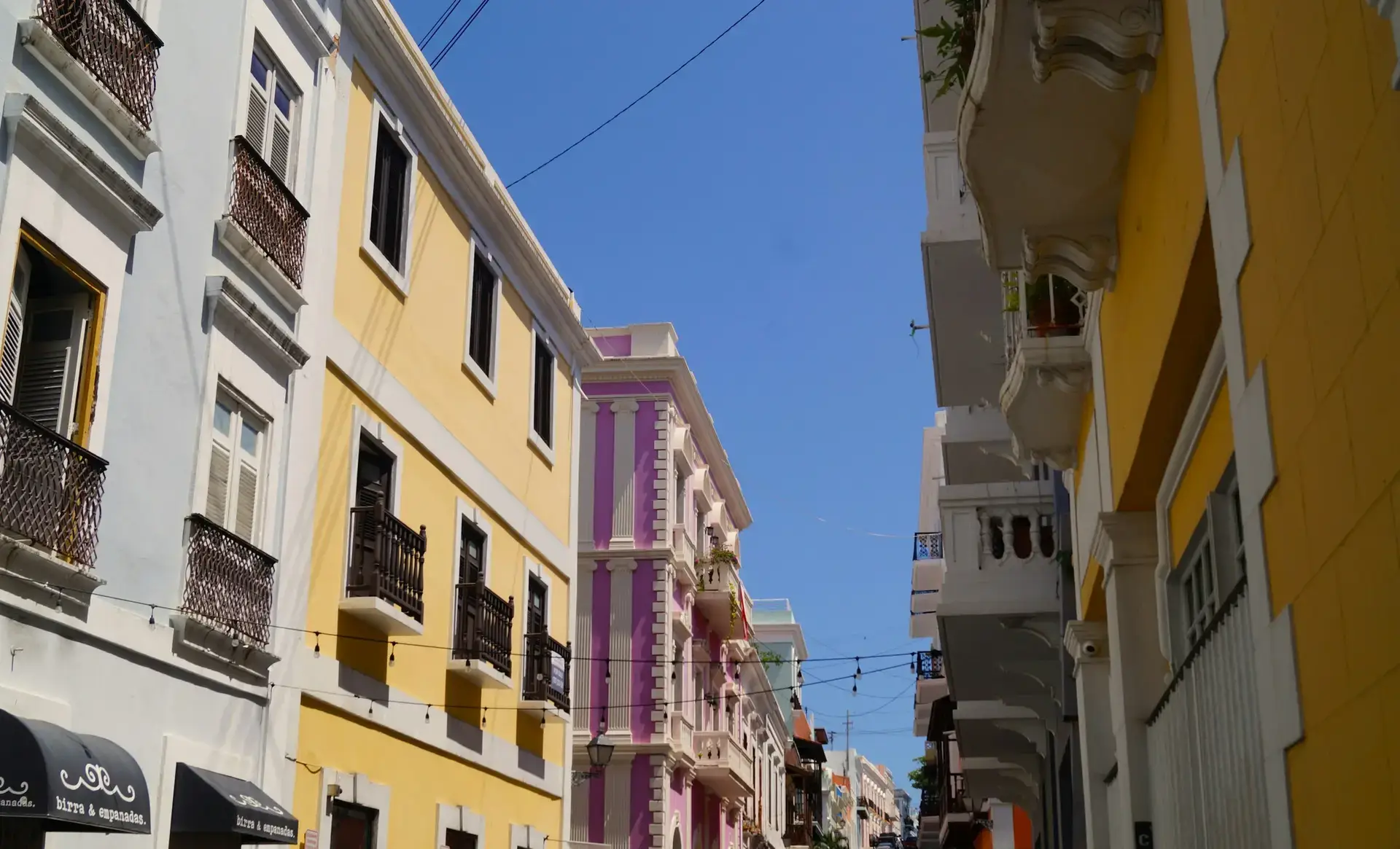 Colorful colonial buildings and balconies along an Old San Juan street in Puerto Rico — Act 60 guide