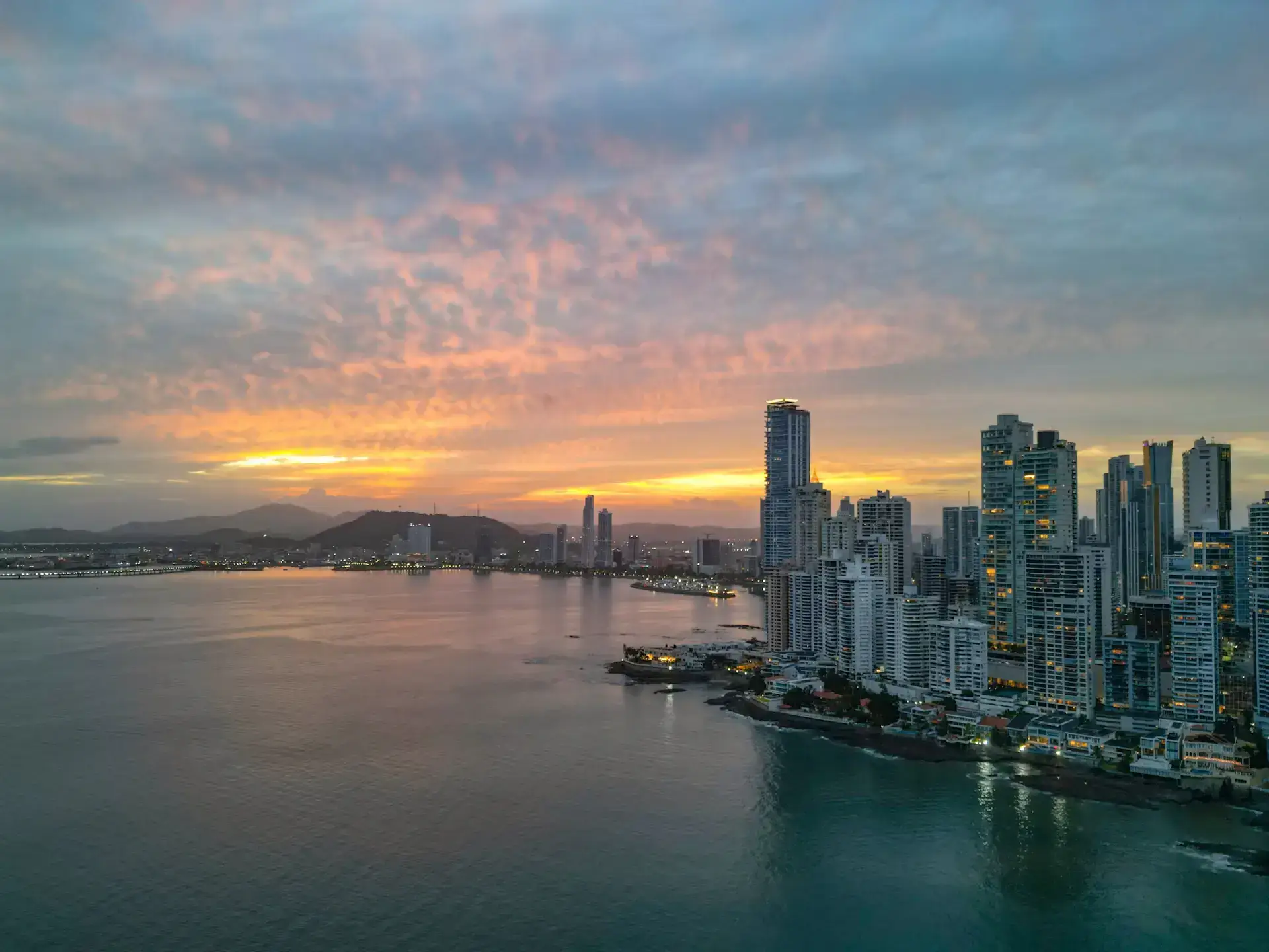 Panama City waterfront towers and bay beneath a colorful sunset