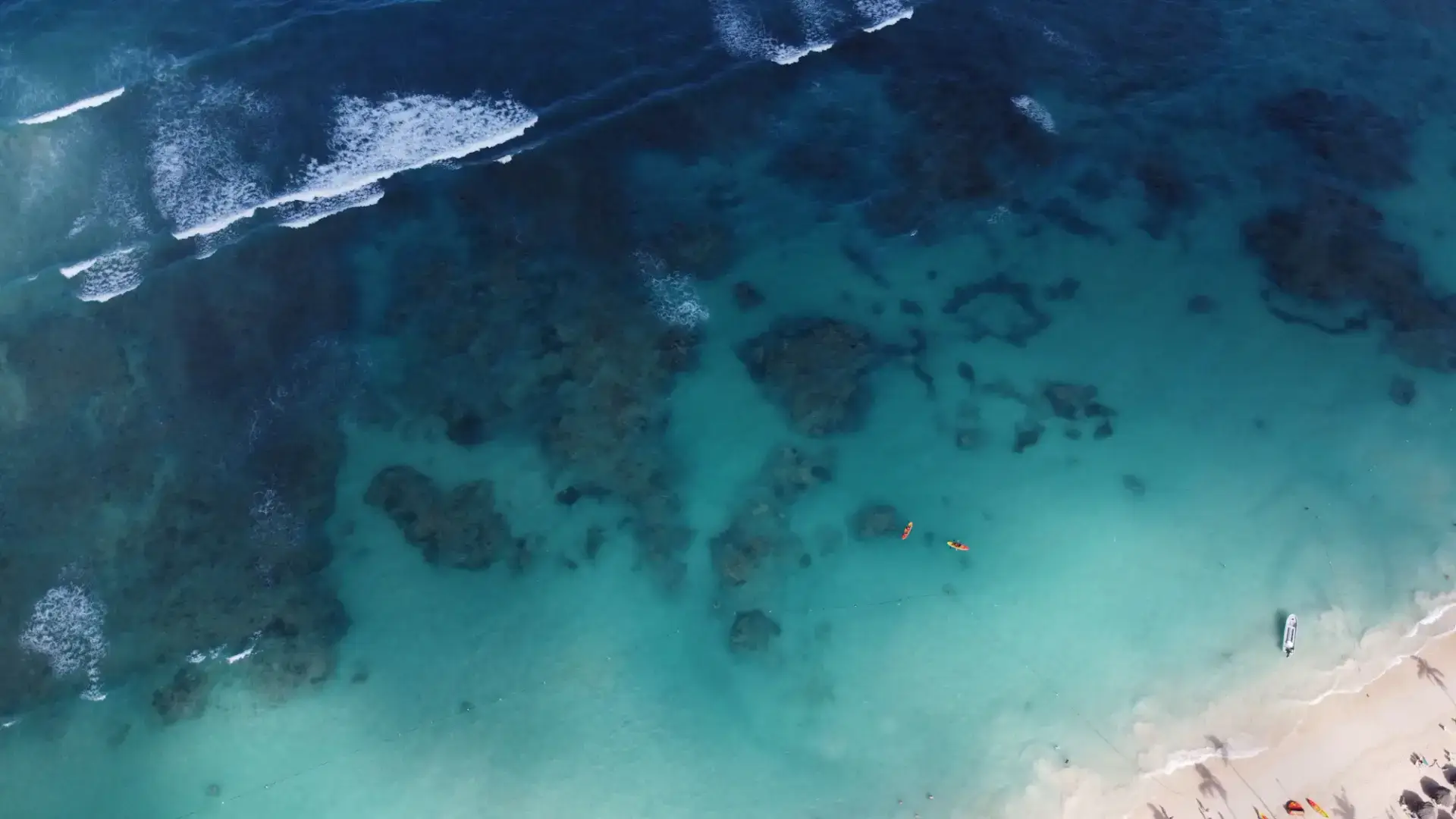 Aerial view of turquoise coastal water, reef patterns and breaking waves in Punta Cana, Dominican Republic