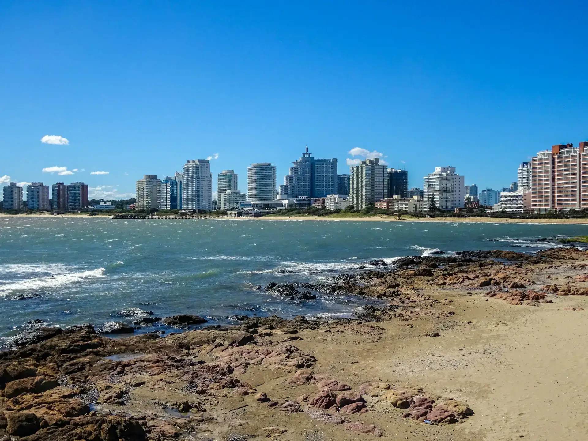 Punta del Este skyline viewed across the water from a rocky beach