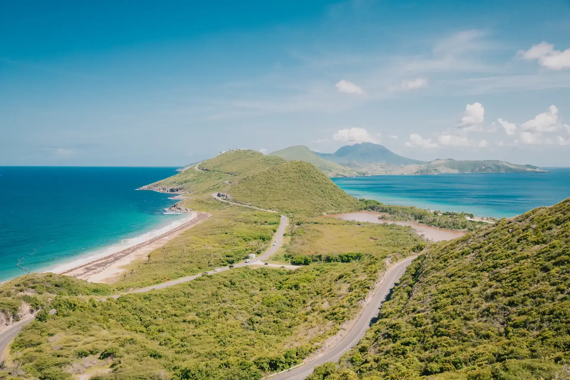 Saint Kitts’ southeastern peninsula, winding road and blue sea viewed from Timothy Hill
