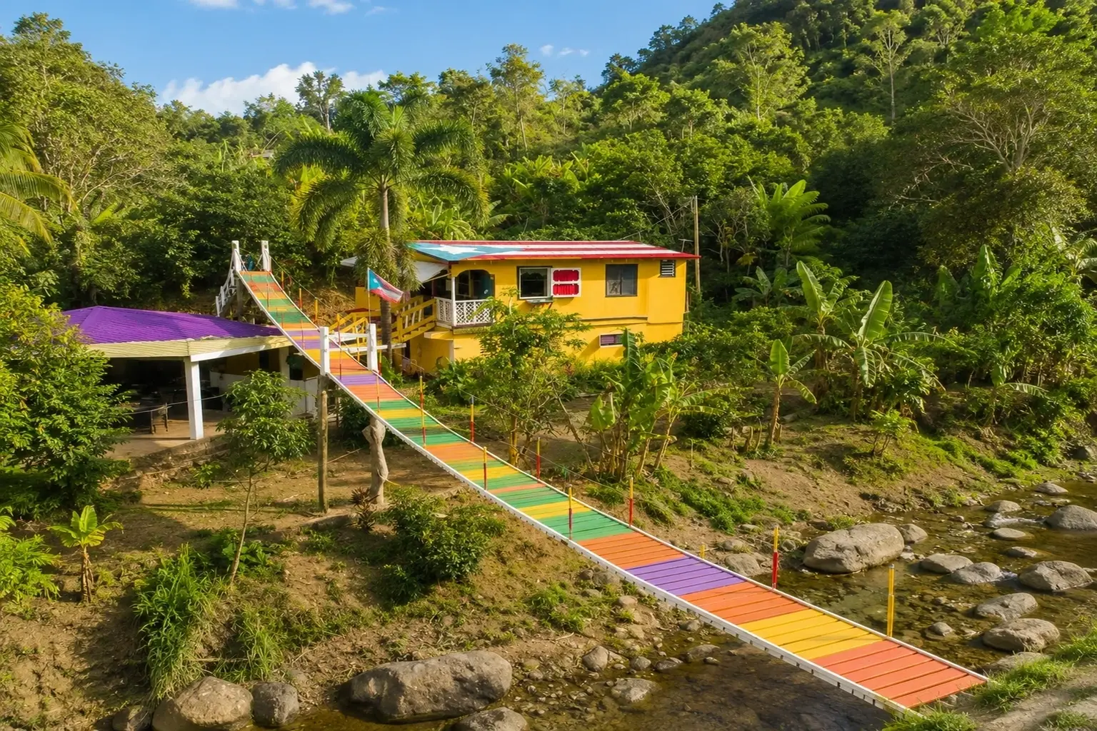 Colorful rural mountain home and footbridge surrounded by tropical vegetation beside a stream in Yahuecas, Adjuntas, Puerto Rico.